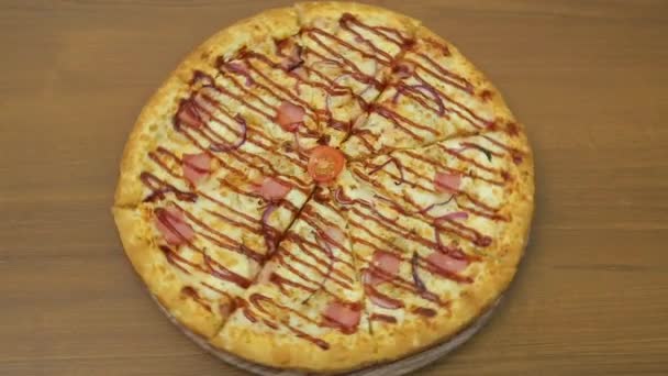 ジューシーなピザは丸いプレート上の円で回転します. — ストック動画