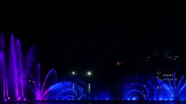 밤에는 다양 한 색깔의 반짝 이는 분수들 이물 속에 반사되어 보인다 — 비디오