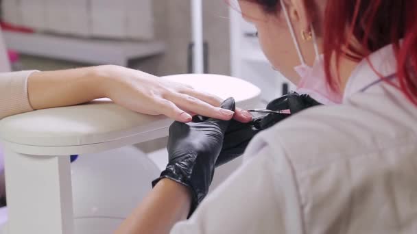 Manikiurzystka w kąpieli kosmetycznej nakłada żel na paznokcie klientów. — Wideo stockowe
