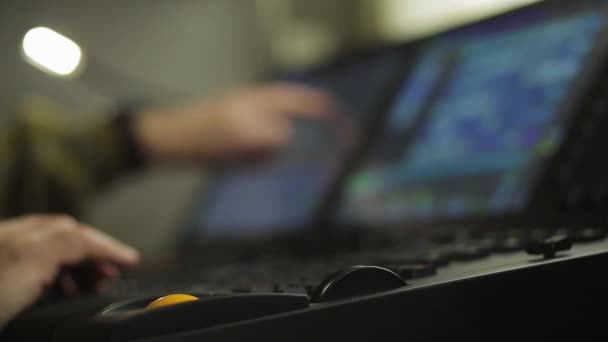 El director del iluminador masculino en el control remoto programa la luz del escenario para el espectáculo. Marco de desenfoque . — Vídeo de stock