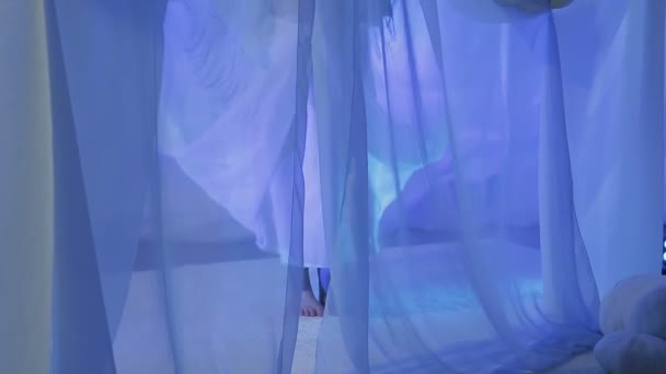 Una joven novia está bailando en la víspera de la boda detrás de una cortina blanca — Vídeos de Stock