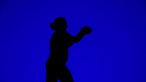 Silhouette d'une femme en gants de boxe pendant l'entraînement . — Video
