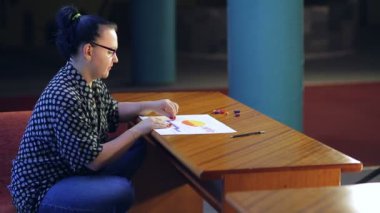 Genç ressam pastel tekniği kullanarak hevesle manzara üzerinde çalışıyor.