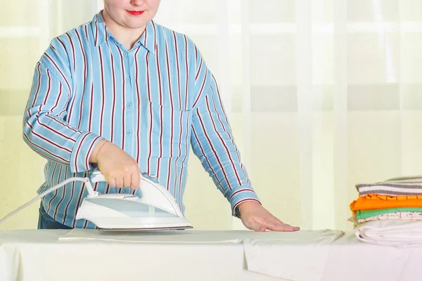 Hausfrau beschäftigt sich mit dem Bügeln von Wäsche. — Stockfoto