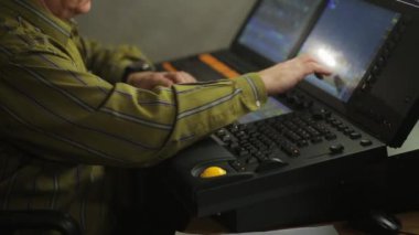 Uzaktan kumandadaki bir erkek aydınlatma operatörü şov için sahne ışığını programlıyor..