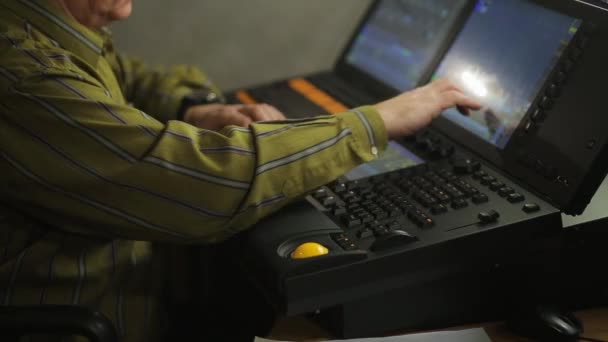 Un operador de iluminación masculino en el control remoto programa la luz de escenario para el espectáculo . — Vídeos de Stock