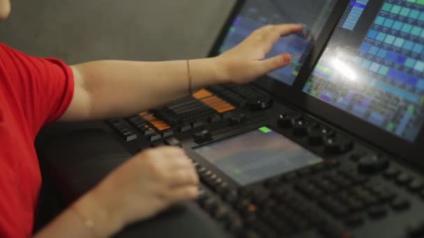 Woman worker illuminator at the remote control programs the stage light for the show — Stock Video