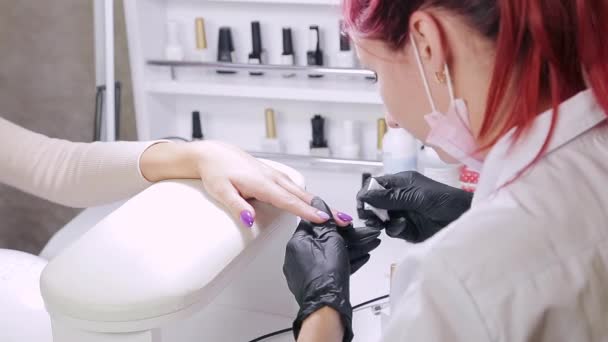 Manicure donna in un salone di bellezza applica un rivestimento opaco su smalto gel — Video Stock
