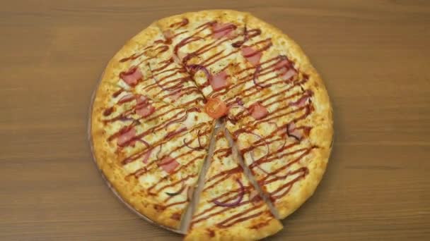 Soczysta pizza obraca się w kółko na okrągłym talerzu — Wideo stockowe