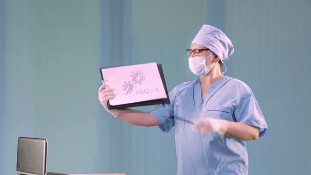 一位戴医疗面具的女医生讲述了一头考拉那病毒，并展示了一张分子图 — 图库视频影像
