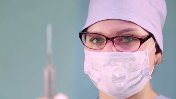Doctora con una máscara médica y una jeringa en la mano — Vídeo de stock