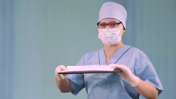 Kobieta w masce lekarskiej nalega, by nie ulegać panice związanej z koronawirusem i zdjąć maskę. — Wideo stockowe