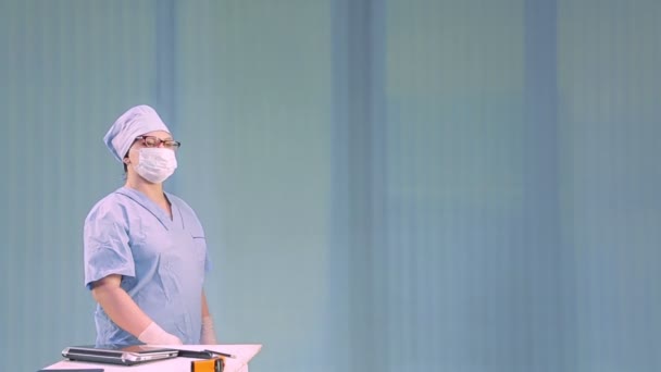 Vrouwelijke arts in een medisch masker met een spuit in haar hand. — Stockvideo