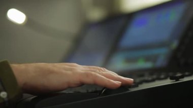 The hand of a male lighting designer at the console programs the stage light for the show. Blur