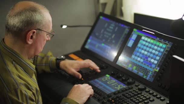 Un pintor masculino en el control remoto programa la luz del escenario para el espectáculo — Vídeos de Stock