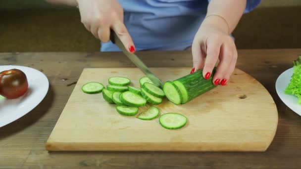 Mulher toca pepino em uma tábua de madeira para salada — Vídeo de Stock
