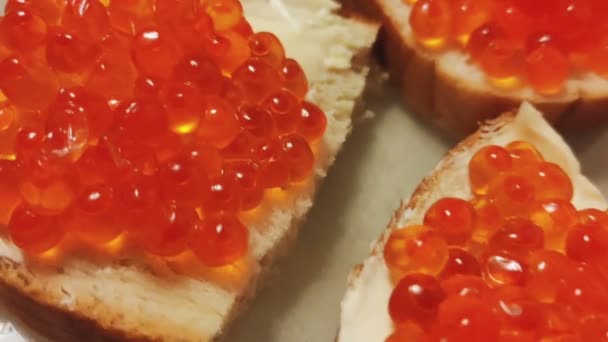 Сэндвичи с маслом и красной икрой на белой тарелке — стоковое видео