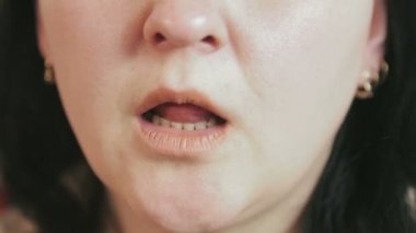 Bir kadın ağzına ilaç koyar ve suyla içer.