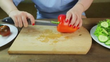 Ahşap salata tahtasında kırmızı biber çekirdeği olan kadın çekirdeği.