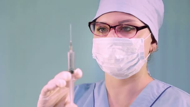 주사기를 손에 들고 의료용 마스크를 쓴 여자 의사 — 비디오