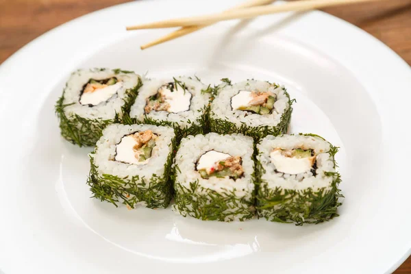 Rolls with salmon and dill on a white plate with chopsticks. — Stock Photo, Image