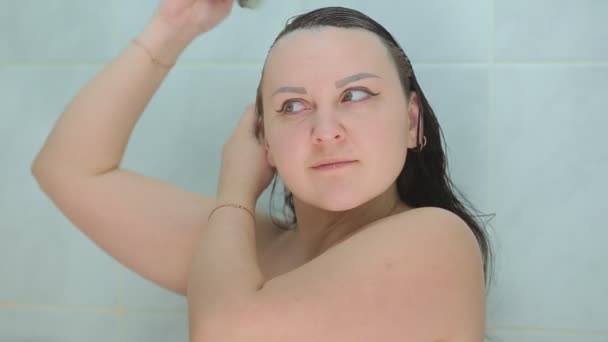Een brunette vrouw verft haar haar met een borstel. — Stockvideo