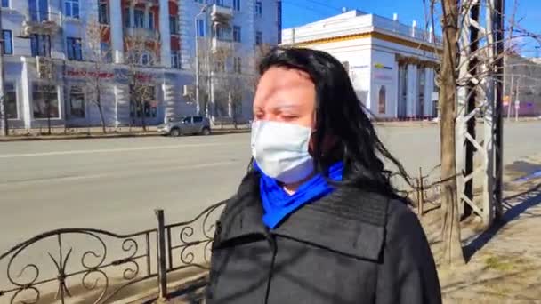 04 de abril de 2020 Rússia, a cidade de Ivanovo, Avenida Lenin. Uma mulher em uma máscara médica caminhando por uma cidade deserta durante a quarentena para combater o coronavírus — Vídeo de Stock