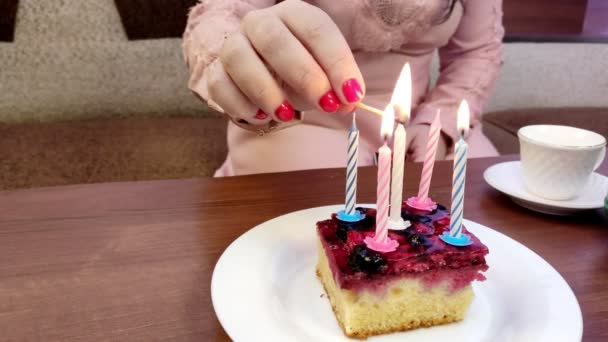 Una mano femenina enciende velas en un pequeño pastel de cumpleaños de cuarentena — Vídeos de Stock