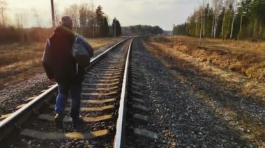 Yorgun adam, sırtından vurulmuş bir bavulla eve dönüyor.