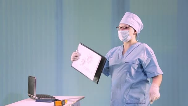 A female doctor in a medical mask tells about a coranavirus and shows a diagram of molecules — Stock Video