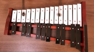 Metal telefon bir insanın elindeki sopalarla çalınır.
