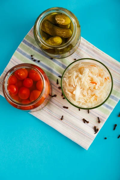 아마포로 된 수건 위에 푸른 배경에 놓인 나무 탁자 위에오이, 토마토, 사우어크 라우트를 올려 놓은 기수들. — 스톡 사진