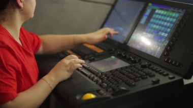 Uzaktan kumandadaki bir kadın aydınlatıcı gösteri için sahne ışığını programlıyor.