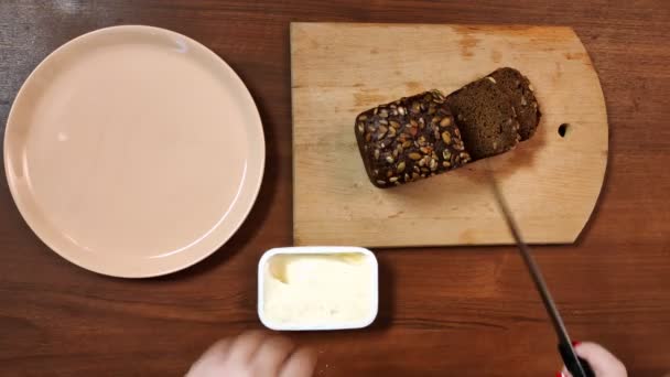 用小刀在木板上切割女性的手，用麦麸切黑麦 — 图库视频影像