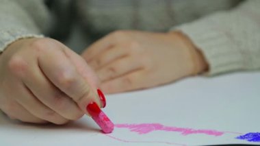 Kadın eli, akşam bulutlarını pembe tebeşirle beyaz kağıda çizer.