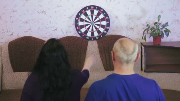Para pod kwarantanną koronawirusów, mąż uczy żonę grać w rzutki. — Wideo stockowe