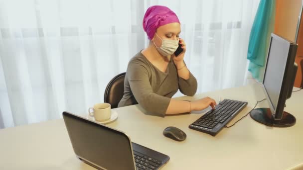 Egy fejdíszt viselő zsidó nő orvosi maszkban a karantén ideje alatt az irodában dolgozik információval.. — Stock videók