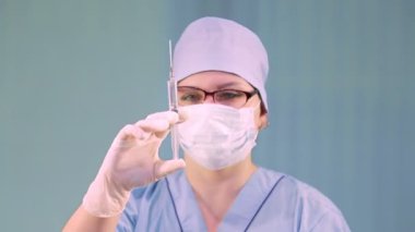 Elinde şırıngayla tıbbi maskeli bir kadın doktor..
