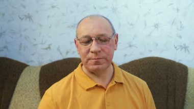 Bir adam bardaktan hafif köpüklü bira içer.