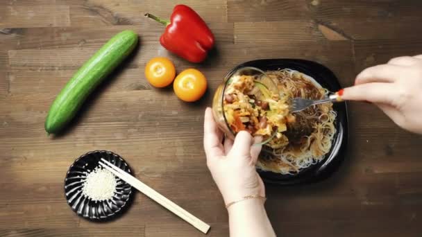 Una mano femminile mette in un piatto con verdure stufate funchoose con pollo un piatto pronto di funchoose con pollo e verdure . — Video Stock