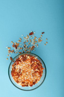 Mavi arka planda sarı mercimek bulunan cam kavanoz..