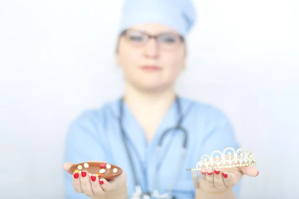 Женщина-врач держит в руках лекарство, и корона на ее лице размыта. . — стоковое фото