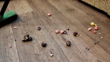 Yerler için fırçayla patlamış mısırı süpüren bir kadın.