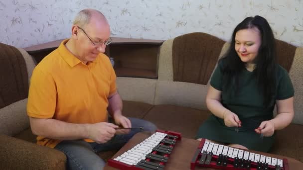 Чоловік і дружина грають металеві навушники вдома . — стокове відео