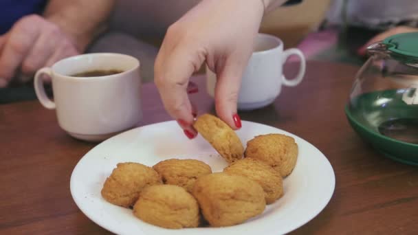 Un uomo e una donna in isolamento bevono tè con i biscotti. Giri di tempo . — Video Stock