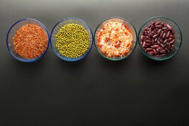 Mısır gevreği taneli cam kavanozlar, mercimek, fasulye, siyah arka planda esmer pirinç..