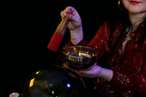 在黑黑的背景下的魔法沙龙里，一个透视者手里拿着一只歌唱杯. — 图库照片