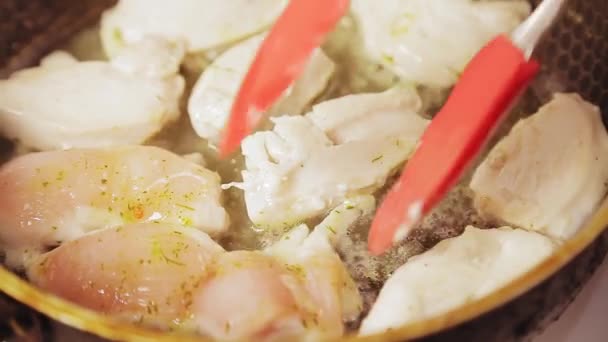 Pinze per carne capovolgono il pollo fritto in una pentola — Video Stock