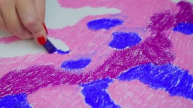 Female hand draws on white paper a pastel sky at sunset. Time Laps.