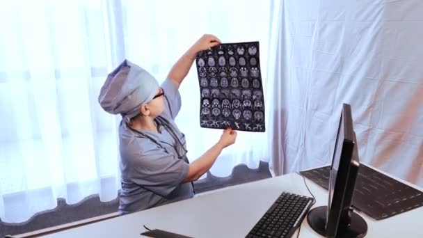 Une femme médecin fait un diagnostic en utilisant des images d'imagerie par résonance magnétique du cerveau — Video